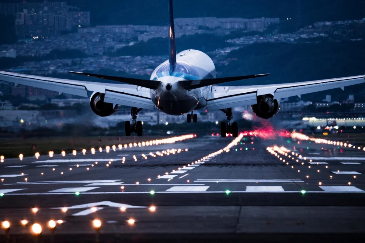 Aircraft touching down on a runway at dusk